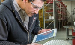 David Plachy inspects a compressor rotor with an SKF Data Collect iPad for reference.