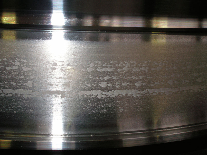 Fig. 3: Example of surface distress: spall bands along the raceway, caused by uneven wear in a cylindrical roller bearing inner ring.